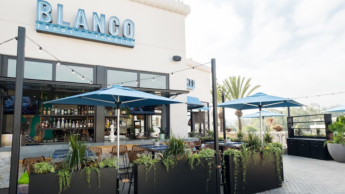 Blanco's patio at Fashion Valley, blue umbrellas and string lights over the bar